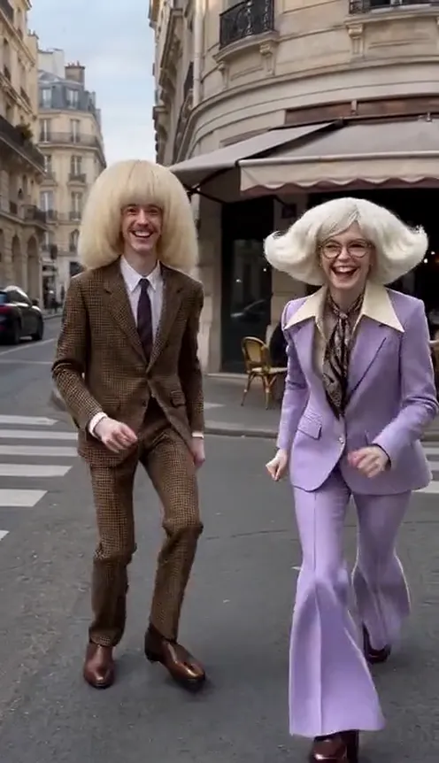 Two friends trade side kicks at the camera on a city street