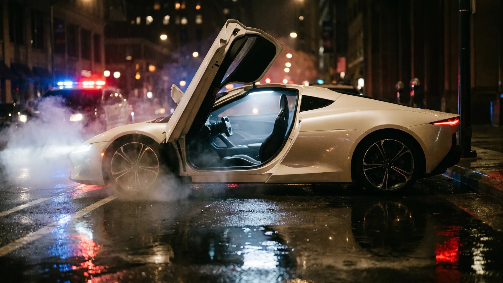 A white unbadged supercar with its driver's door open and an empty seat on a wet night street, lit by red and blue police lights, with white vapour drifting on the ground