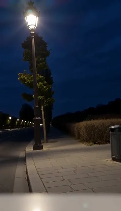 Streetlight Slip AI example: a man waves under a street lamp at night, slips out of frame and pops back in as a close-up selfie