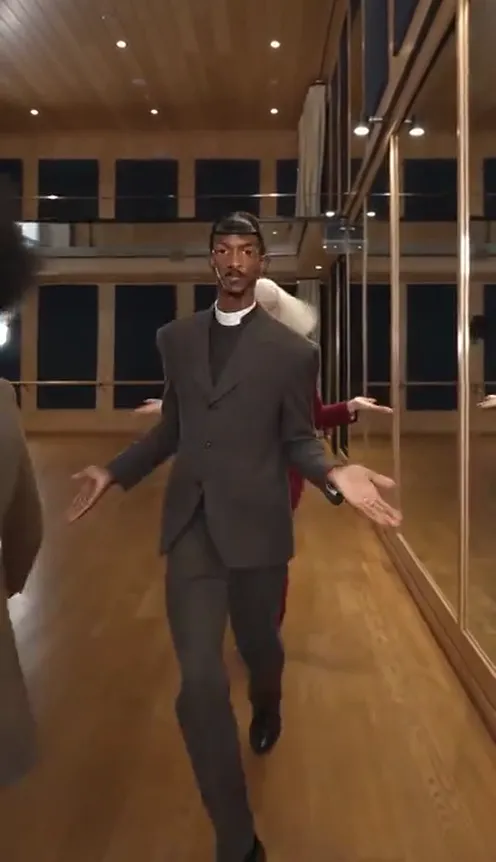 Four friends in their own clothes take turns dancing toward the low camera in a mirrored dance studio with a wooden floor
